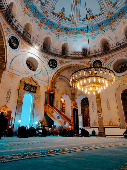 Free Captured inside a historic mosque, featuring an ornate dome and worshippers. Stock Photo