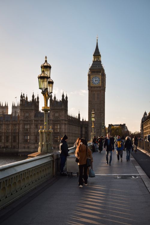 Free People walking on Westminster Bridge with Big Ben and Parliament in the background at sunset. Stock Photo