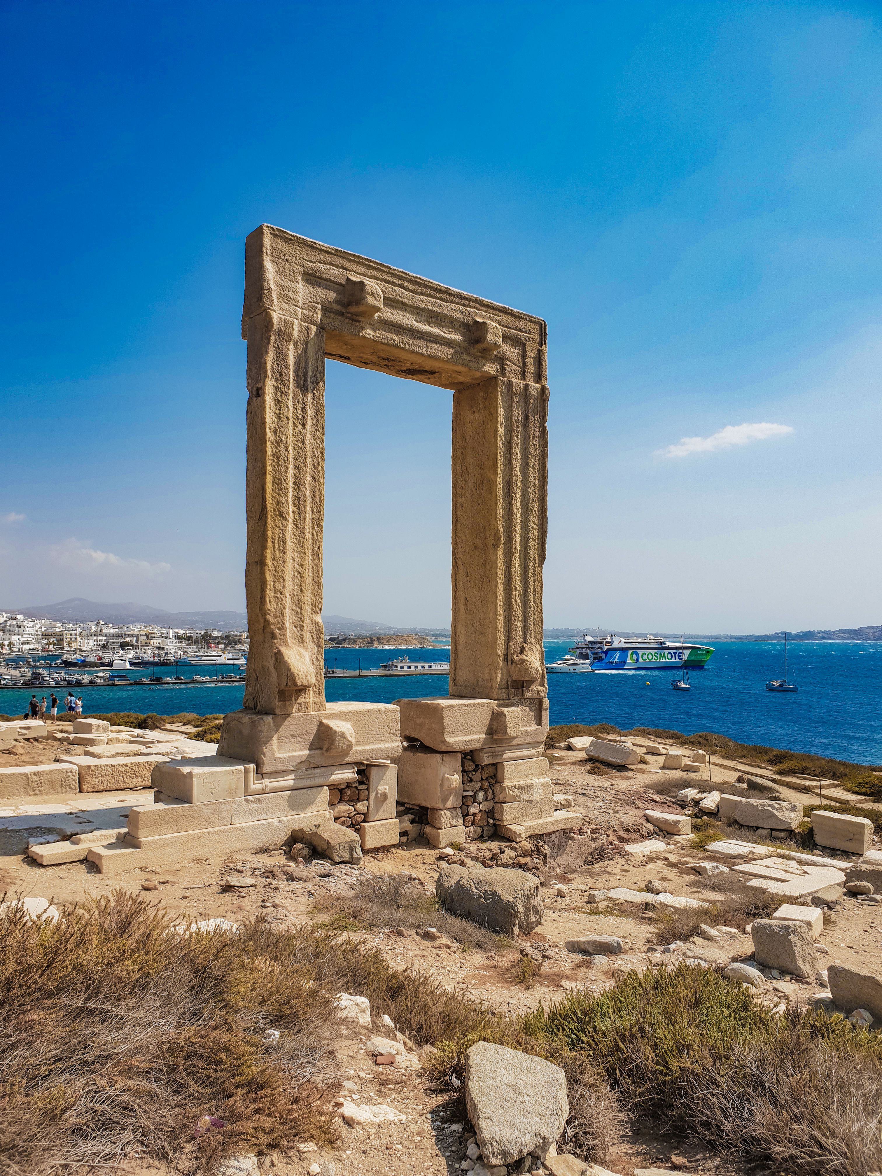 The ancient Portara marble gate on Naxos island with the Aegean Sea and blue sky