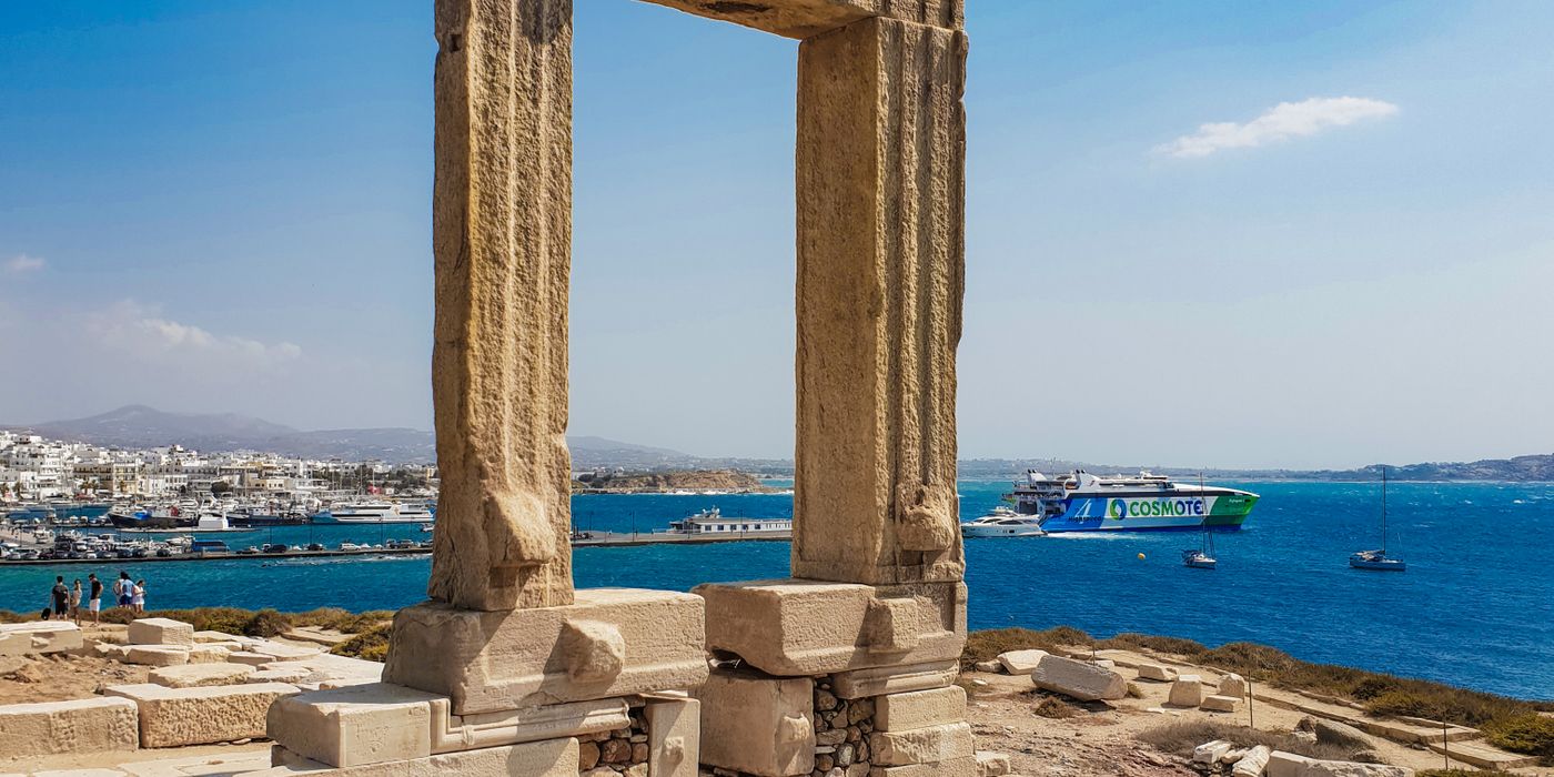 The ancient Portara marble gate on Naxos island with the Aegean Sea and blue sky