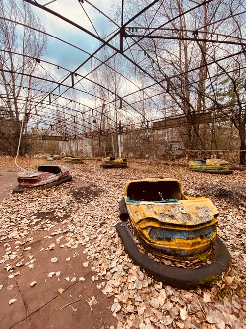 Free Eerie abandoned bumper cars amidst overgrown foliage in Chernobyl, Ukraine. Stock Photo