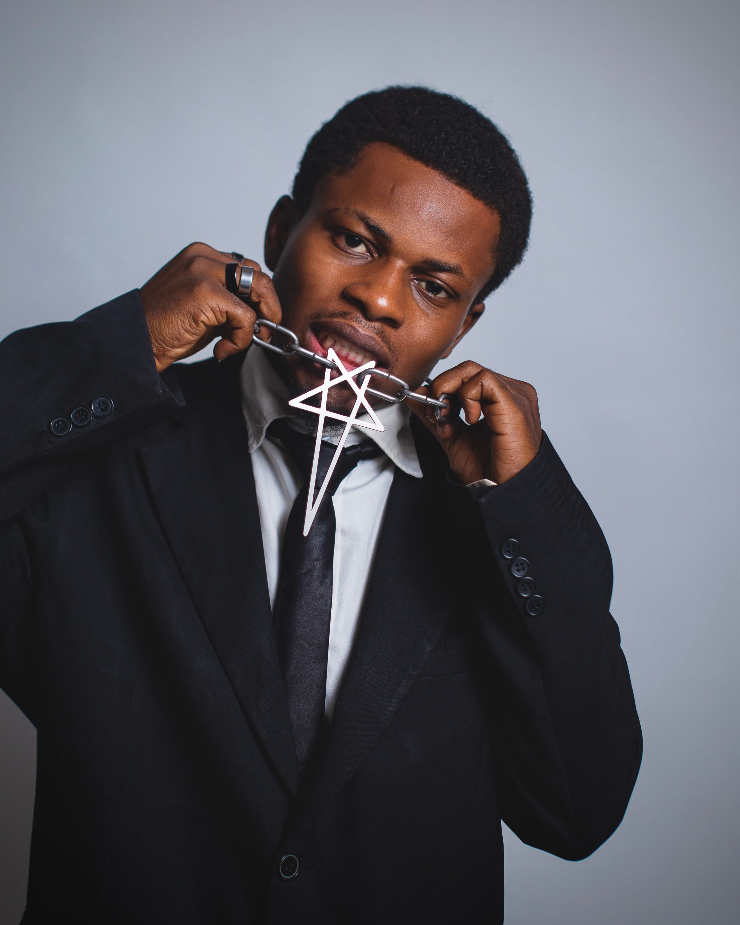 Portrait of a man in a suit holding a geometric design, showcasing unique style and expression.