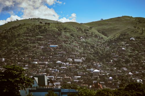 Free A picturesque hillside village with numerous houses, capturing lush greenery and clear skies. Stock Photo