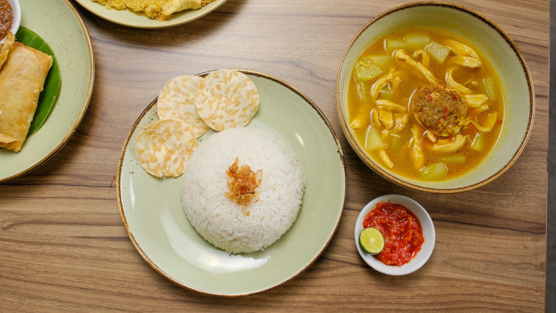 Top view of Indonesian dishes with rice, curry, and sambal, showcasing traditional flavors.