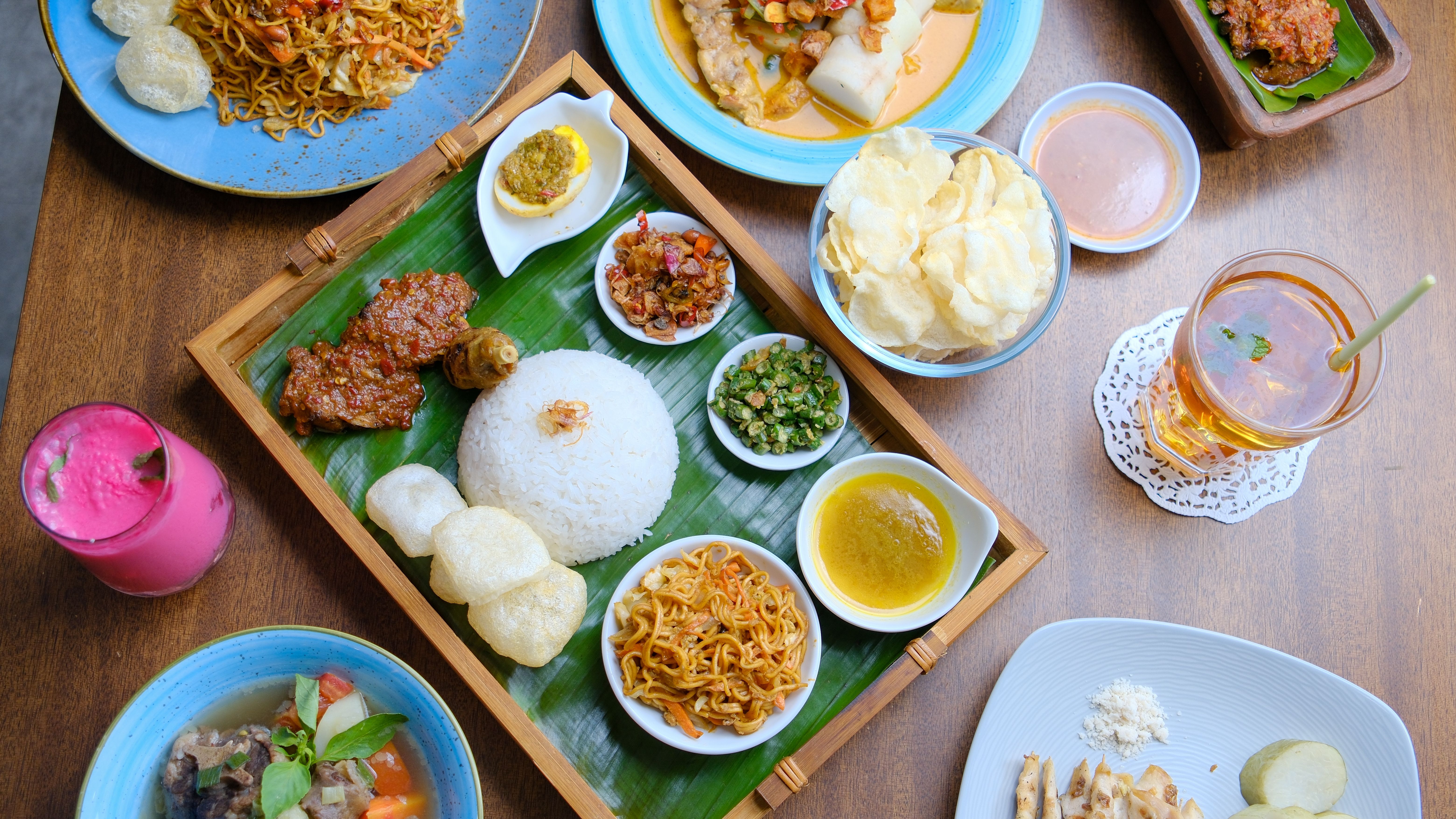 An inviting spread of authentic Indonesian dishes laid out on a wooden table, perfect for food enthusiasts.