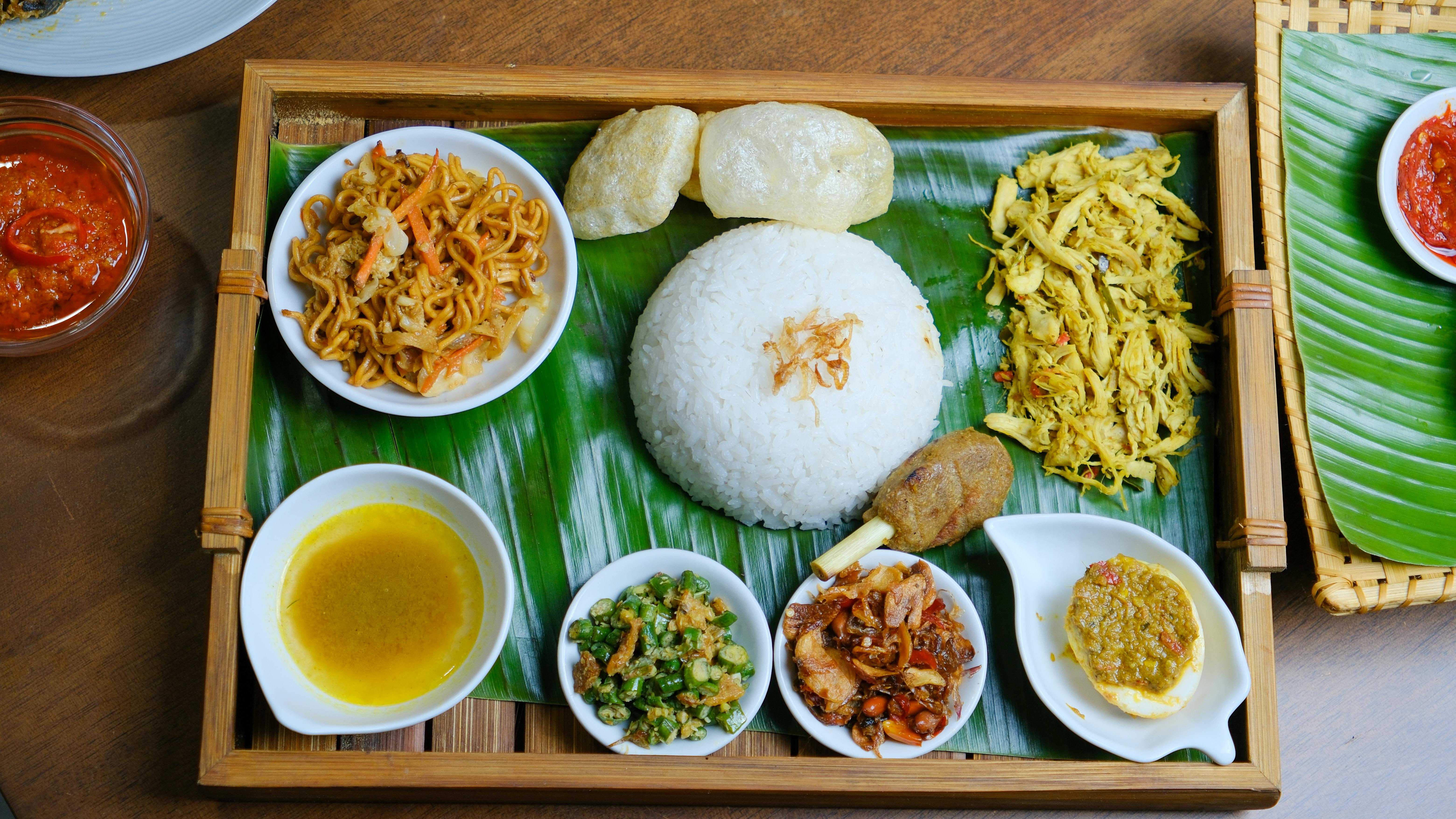 Local warung nasi campur plate with tempeh, tofu, urap and vegetables served on rice in Bali