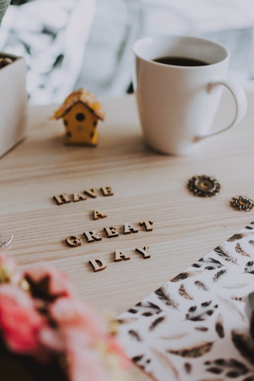 Free White Ceramic Mug Beside Brown Wooden House Ornament Stock Photo