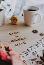 White Ceramic Mug Beside Brown Wooden House Ornament