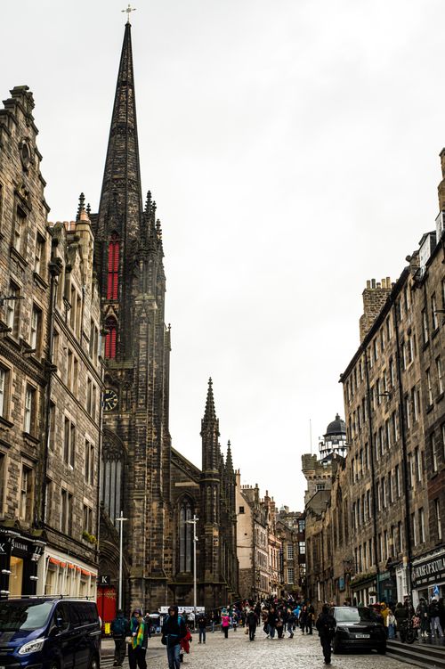 Free View of a busy street in Edinburgh featuring historic architecture and a prominent church spire. Stock Photo