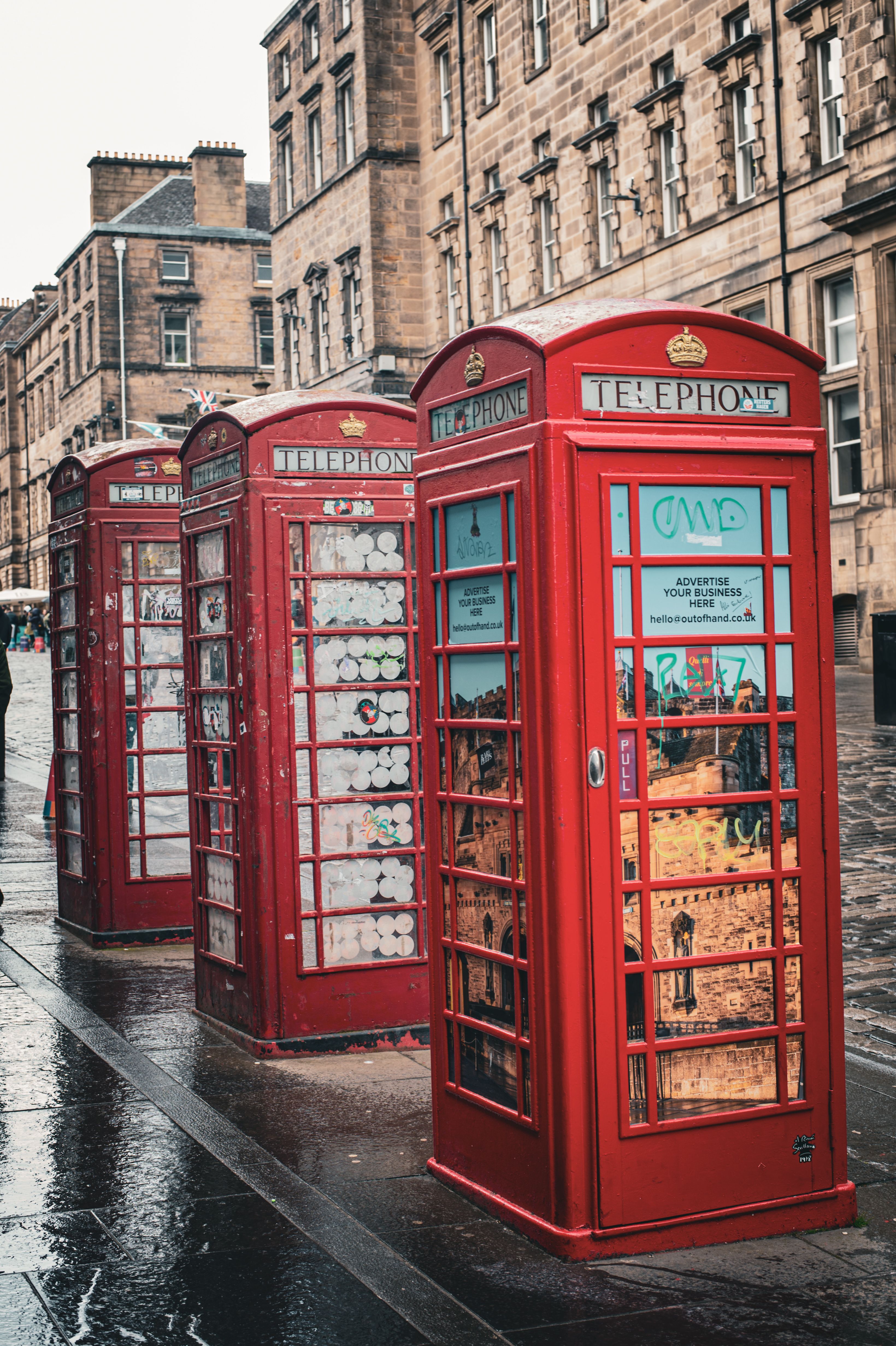 Iconic Red Telephone Booths on a Rainy Street · Free Stock Photo