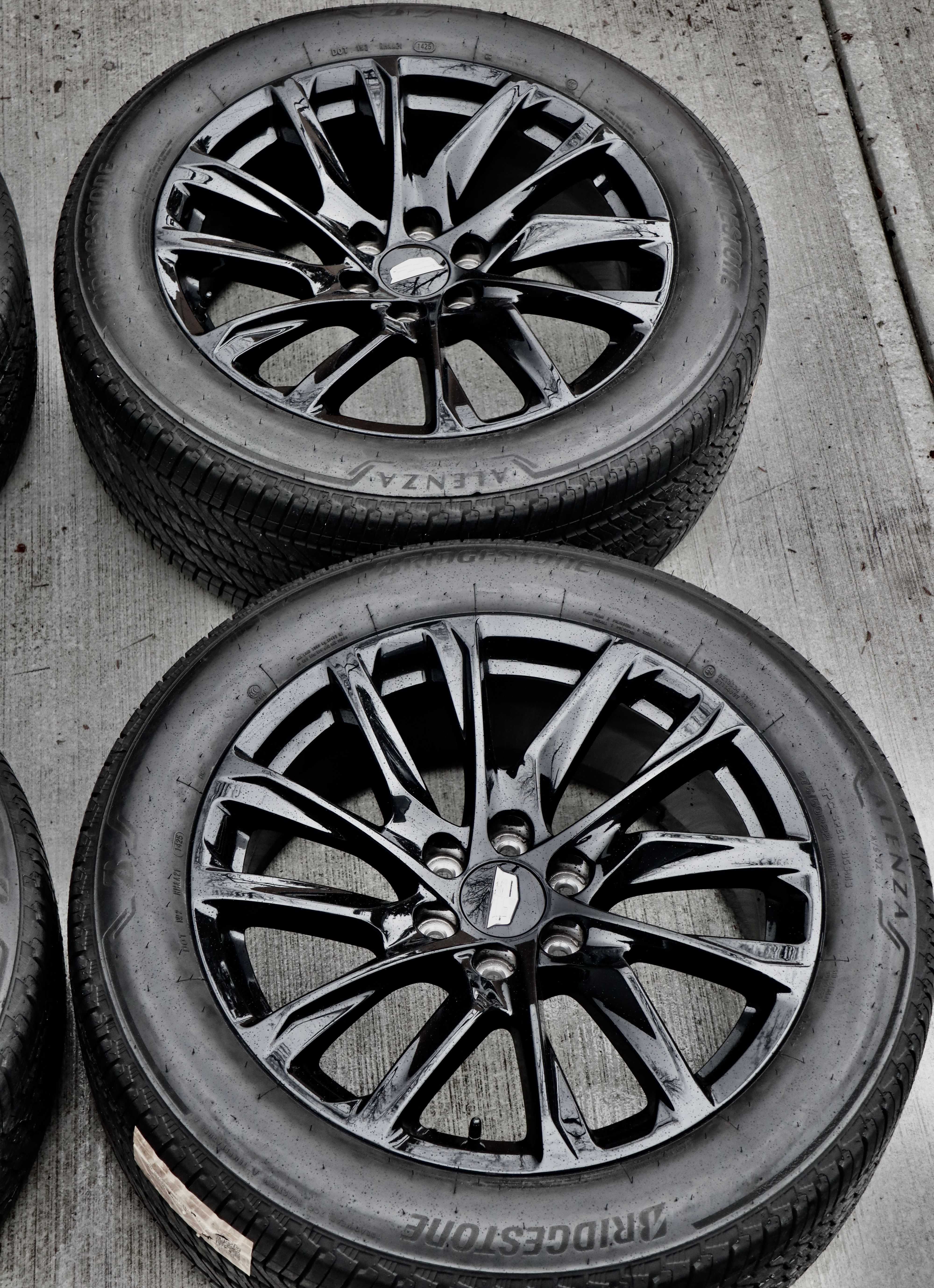 Shiny Black Alloy Wheels on Concrete Surface · Free Stock Photo