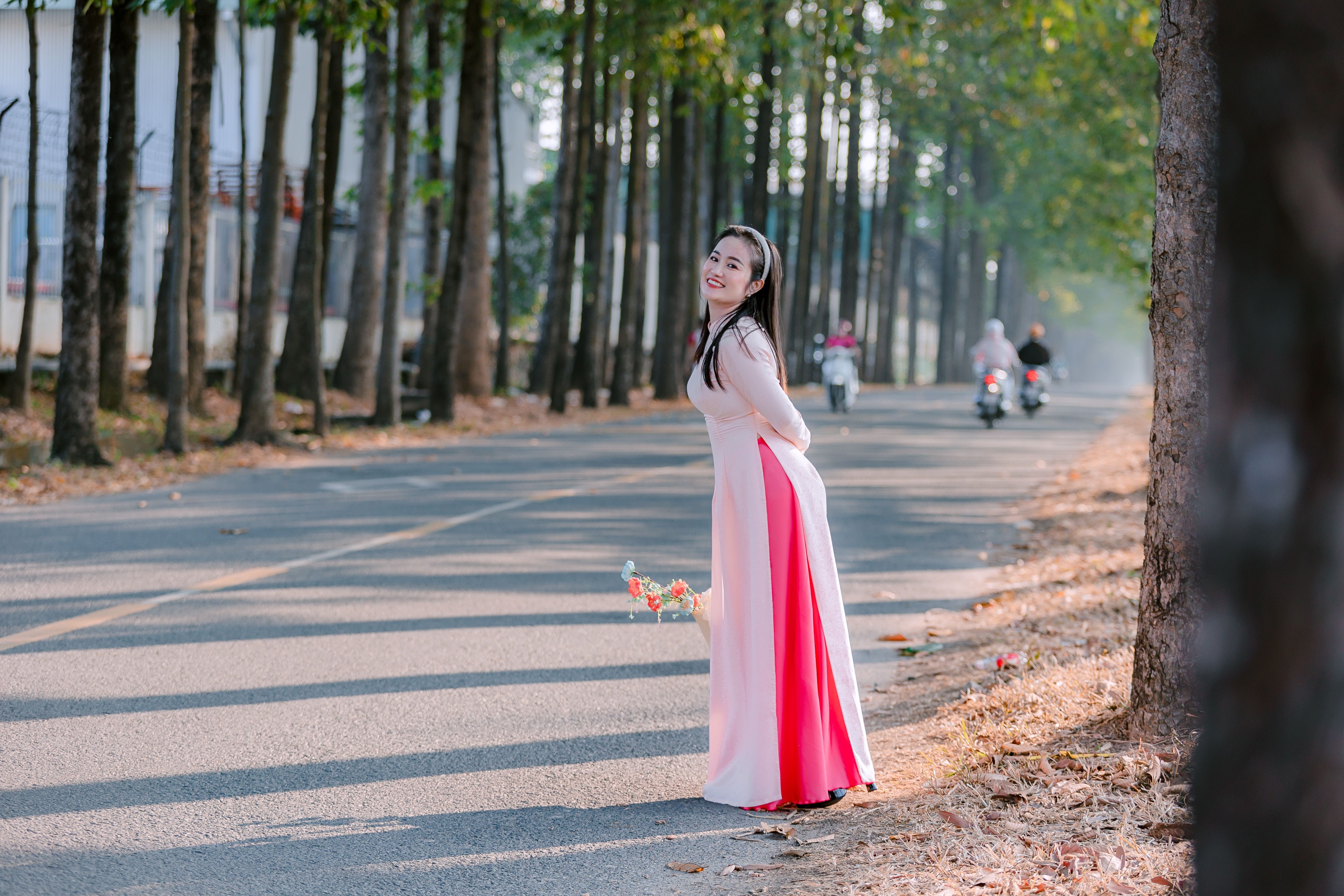 Woman in Traditional Dress Smiling on Forest Road · Free Stock Photo