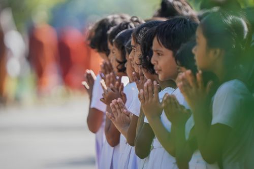 Free A group of school children in white uniforms participate in a religious procession, hands folded in prayer. Stock Photo
