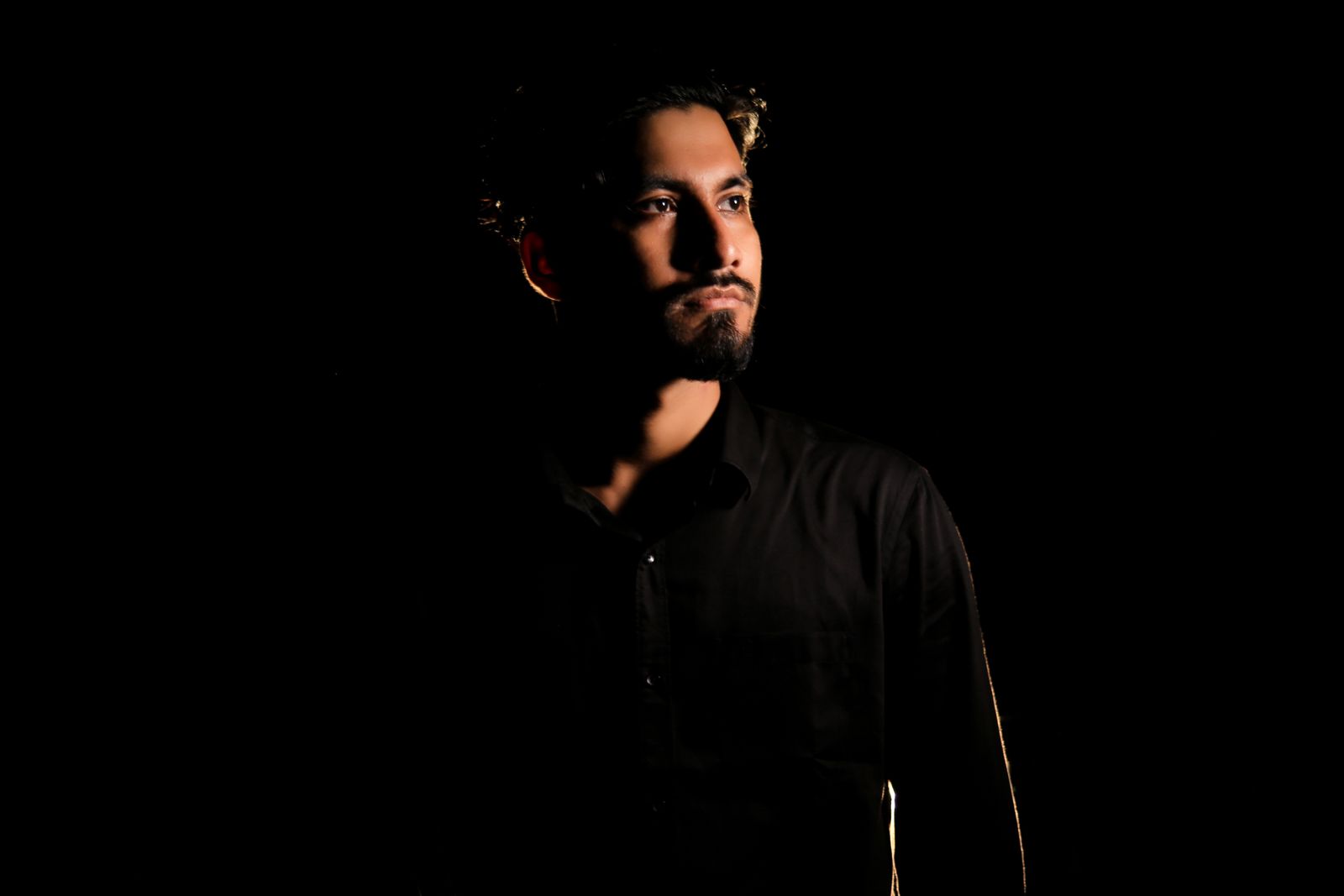 Key art for Ember of the City of Salt: a low-key portrait of the lead in shadow. Photo by H R Mahin on Pexels