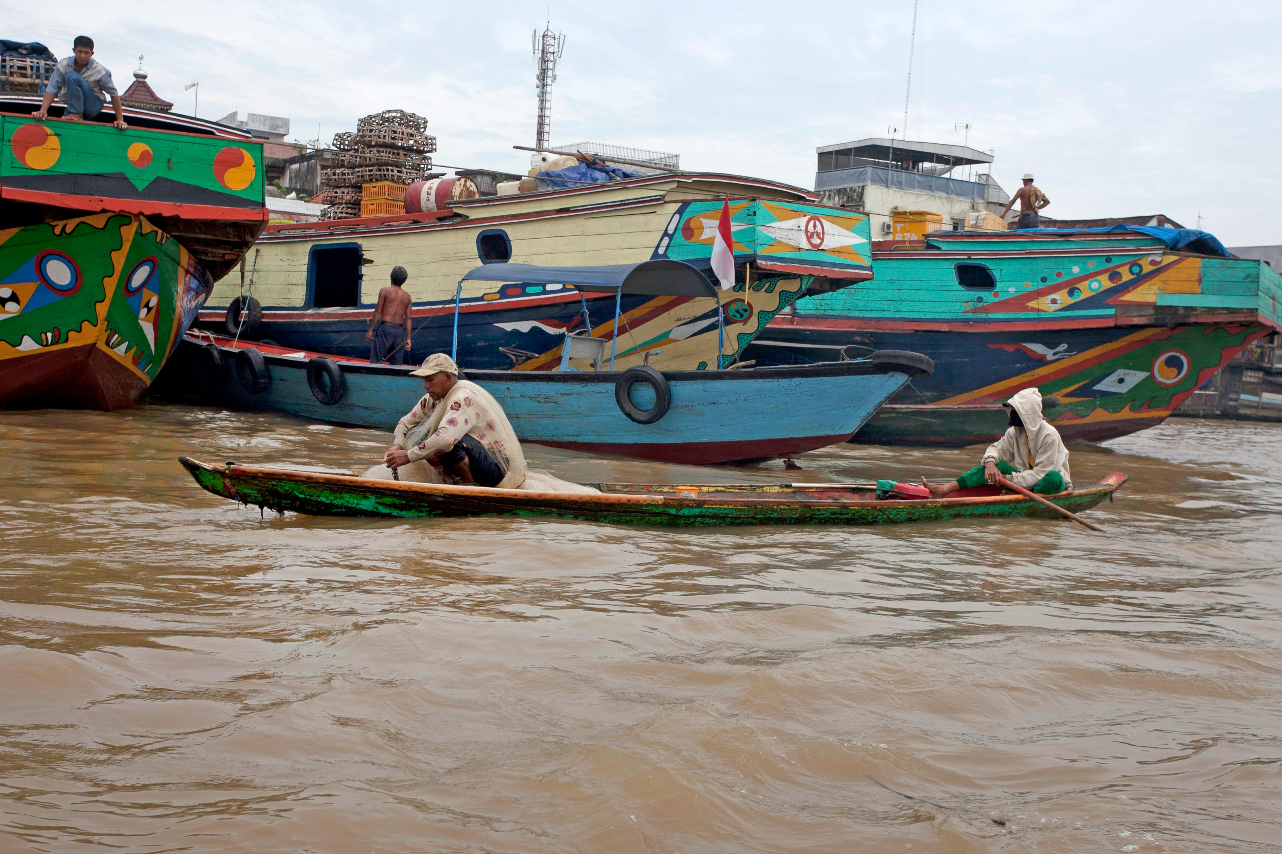 Vibrantly painted boats navigate a bustling river, highlighting local waterway life.
