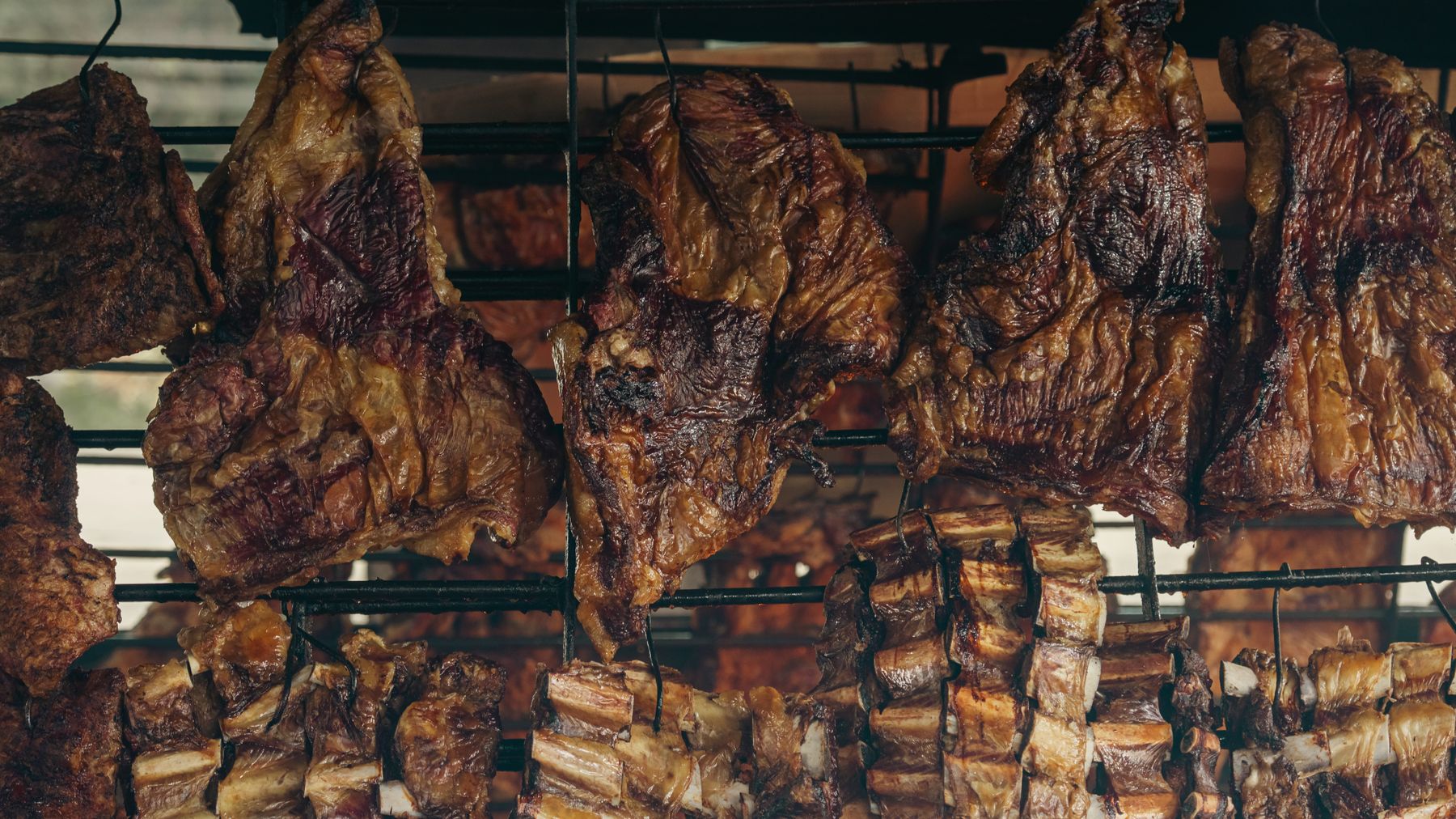 Close-up of meats roasting on a traditional Argentine parilla grill in Uribelarrea.