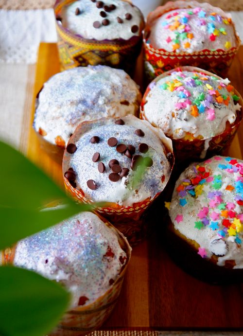 Free Brightly decorated cupcakes with frosting, chocolate chips, and sprinkles on a wooden board. Stock Photo