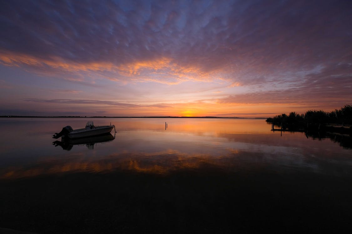 Siluet Perahu Di Air Tenang Saat Matahari Terbenam