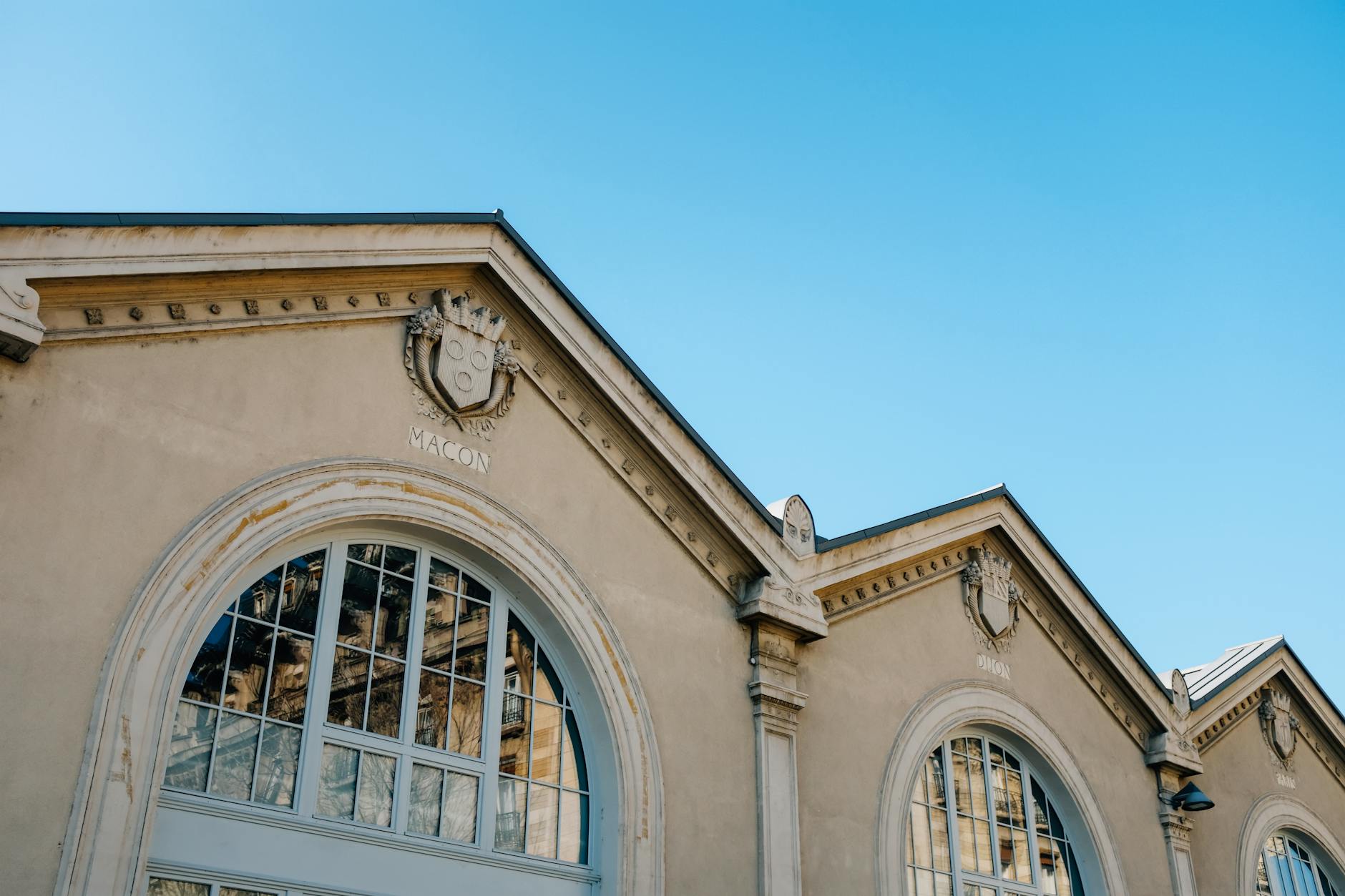 Elegant historic building facade with arched windows against a clear blue sky.