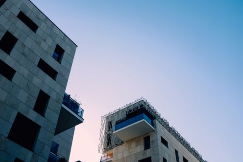 Free Low-angle shot of modern urban buildings against a clear blue sky. Stock Photo