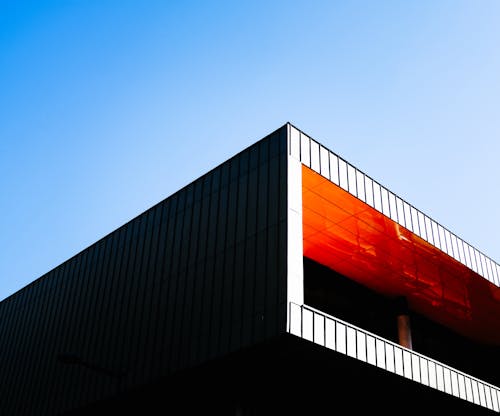 免费 蓝蓝的天空下的橙色和黑色混凝土建筑 素材图片