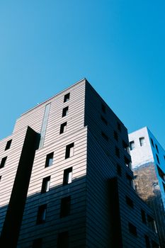 现代建筑外观的低角度视图，在清澈蓝天的映衬下，展现了建筑设计之美