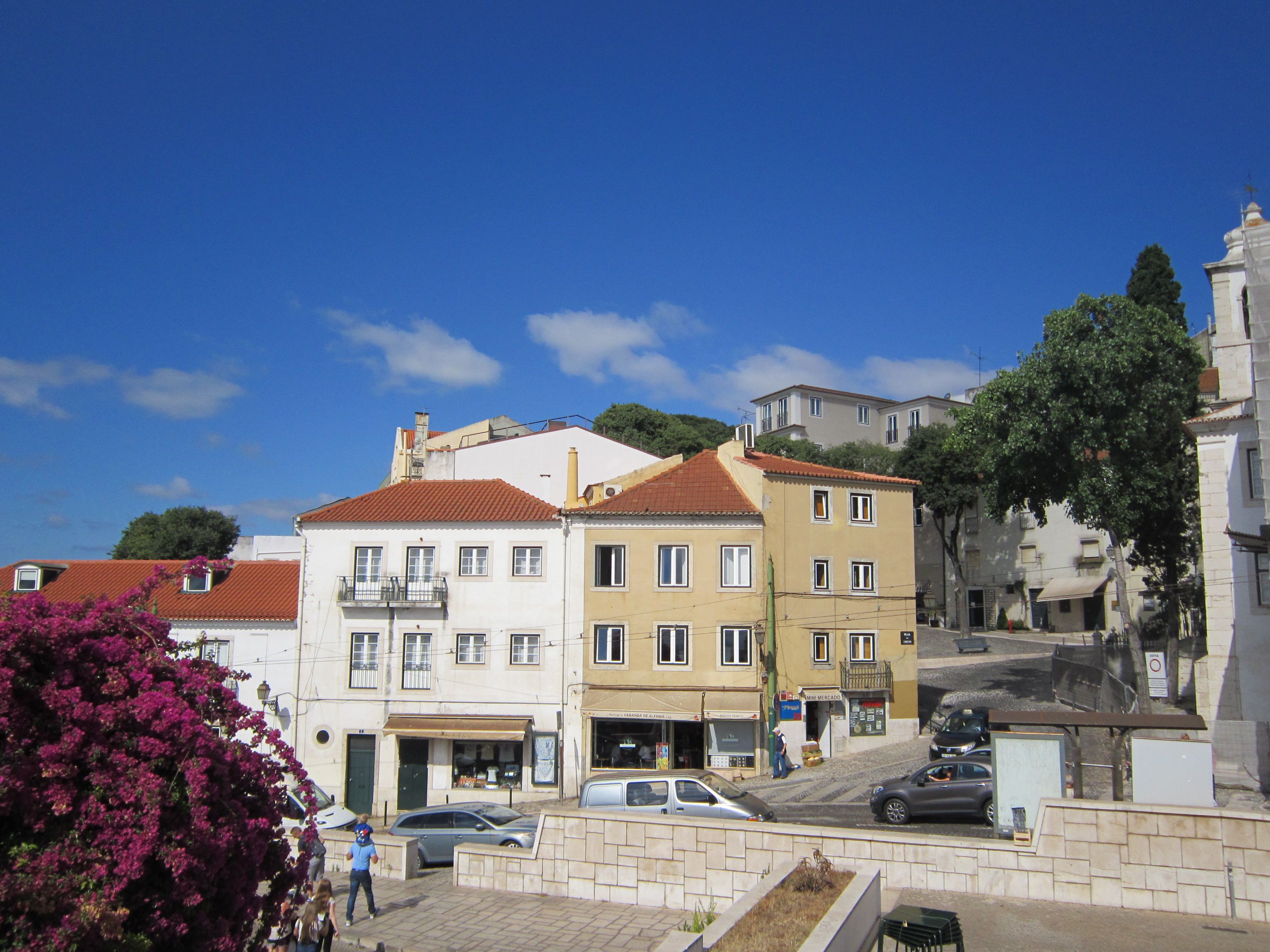 Pastel embassy villas on a steep Lapa street with the Tagus visible at the bottom of the hill