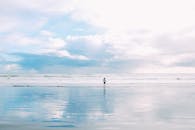 一个孤独的人在宁静的海滩日站在海边