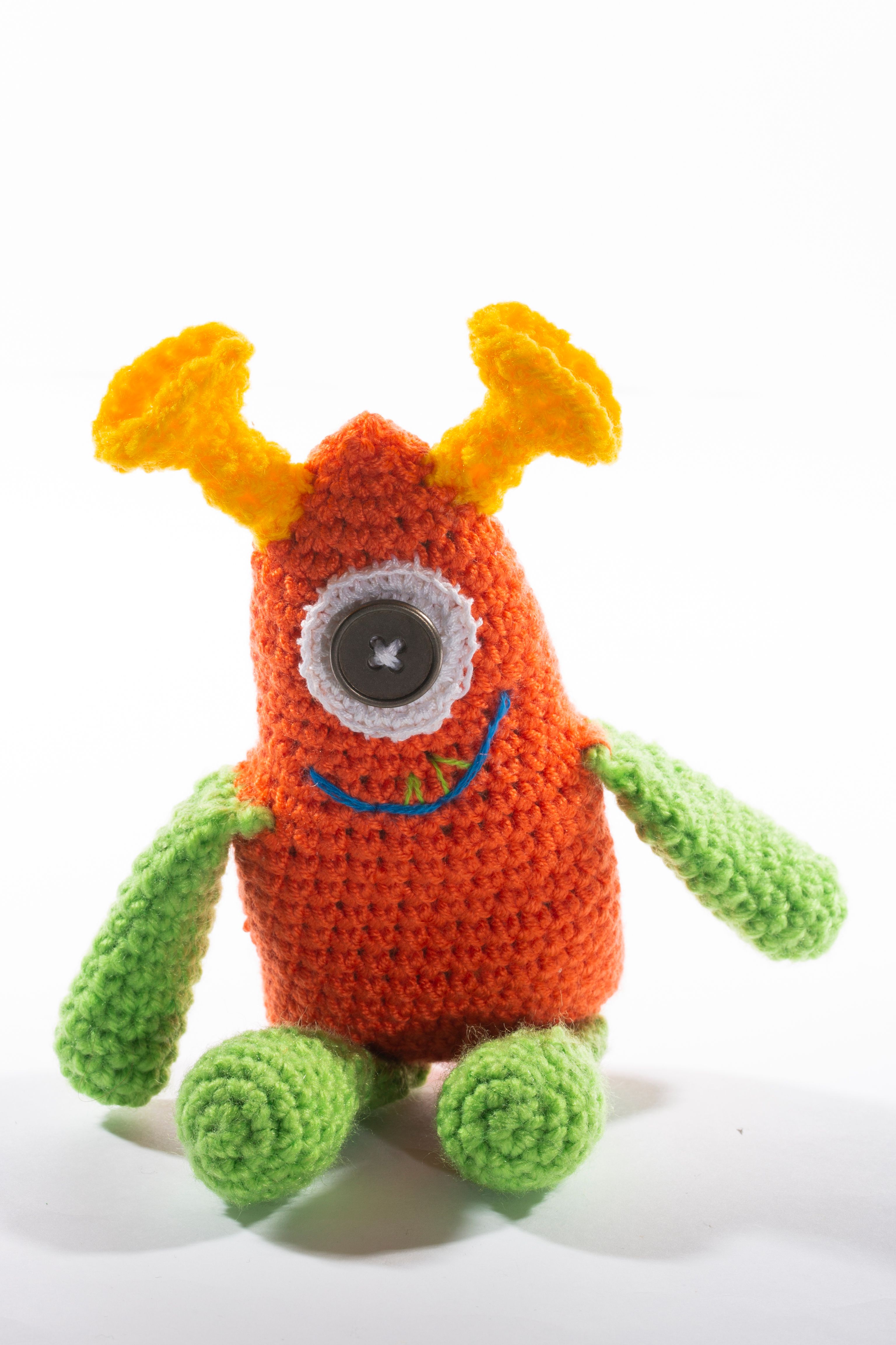 Vibrant crocheted monster toy with one eye and playful colors, perfect for kids.