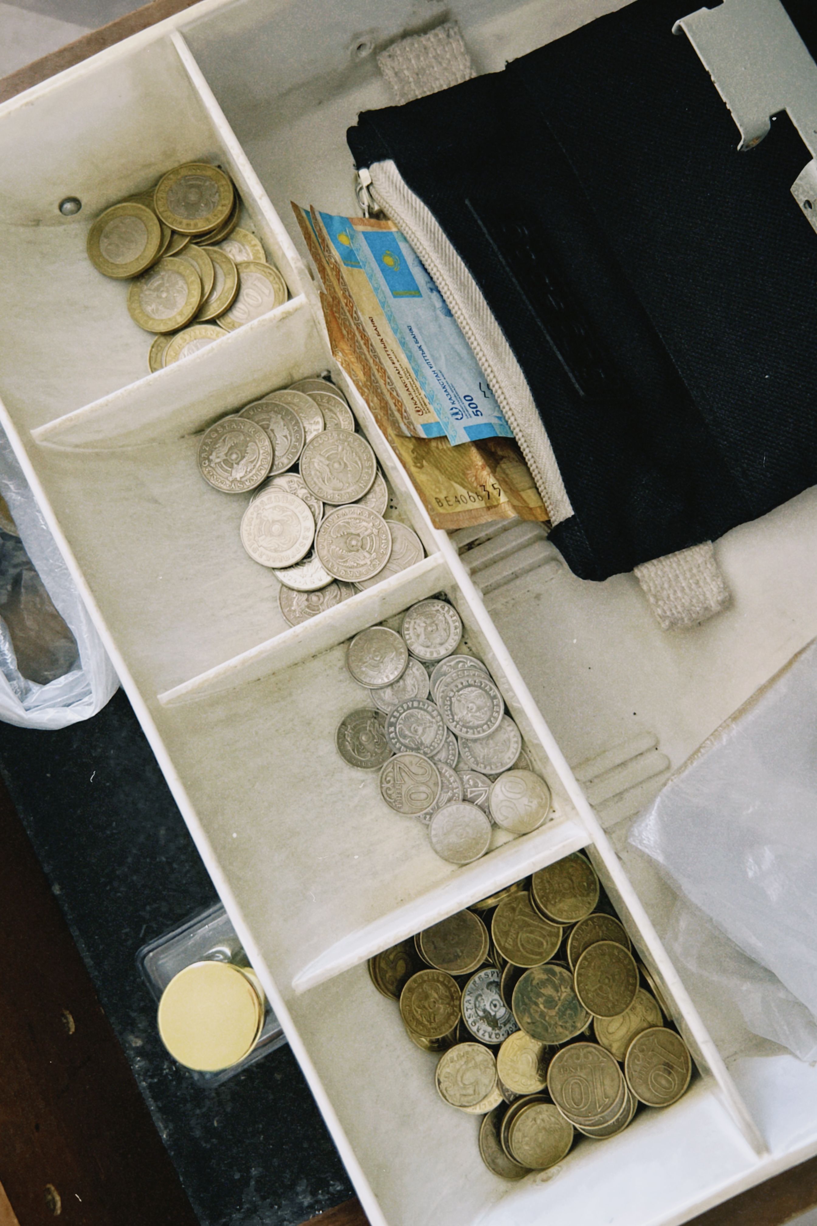 Coins and banknotes arranged in a cash drawer compartment