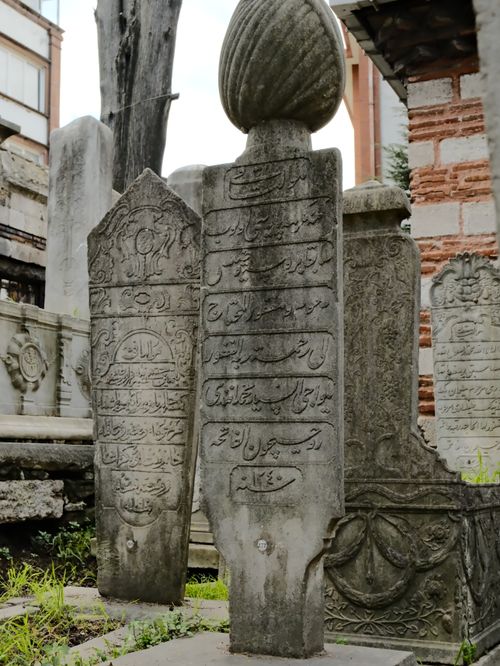 Free Ancient gravestones in a Turkish cemetery showcasing Ottoman script and stone carvings. Stock Photo