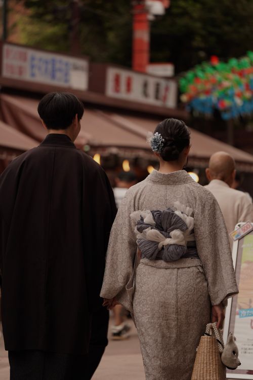 Free Elegant couple in kimono strolling through vibrant Tokyo street, embracing Japanese culture. Stock Photo