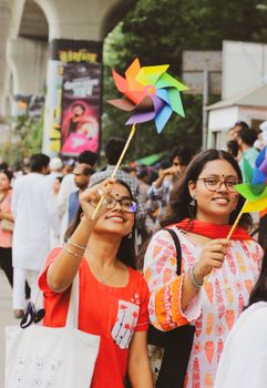 Bright Asian celebration with women enjoying pinwheels in Dhaka, Bangladesh.