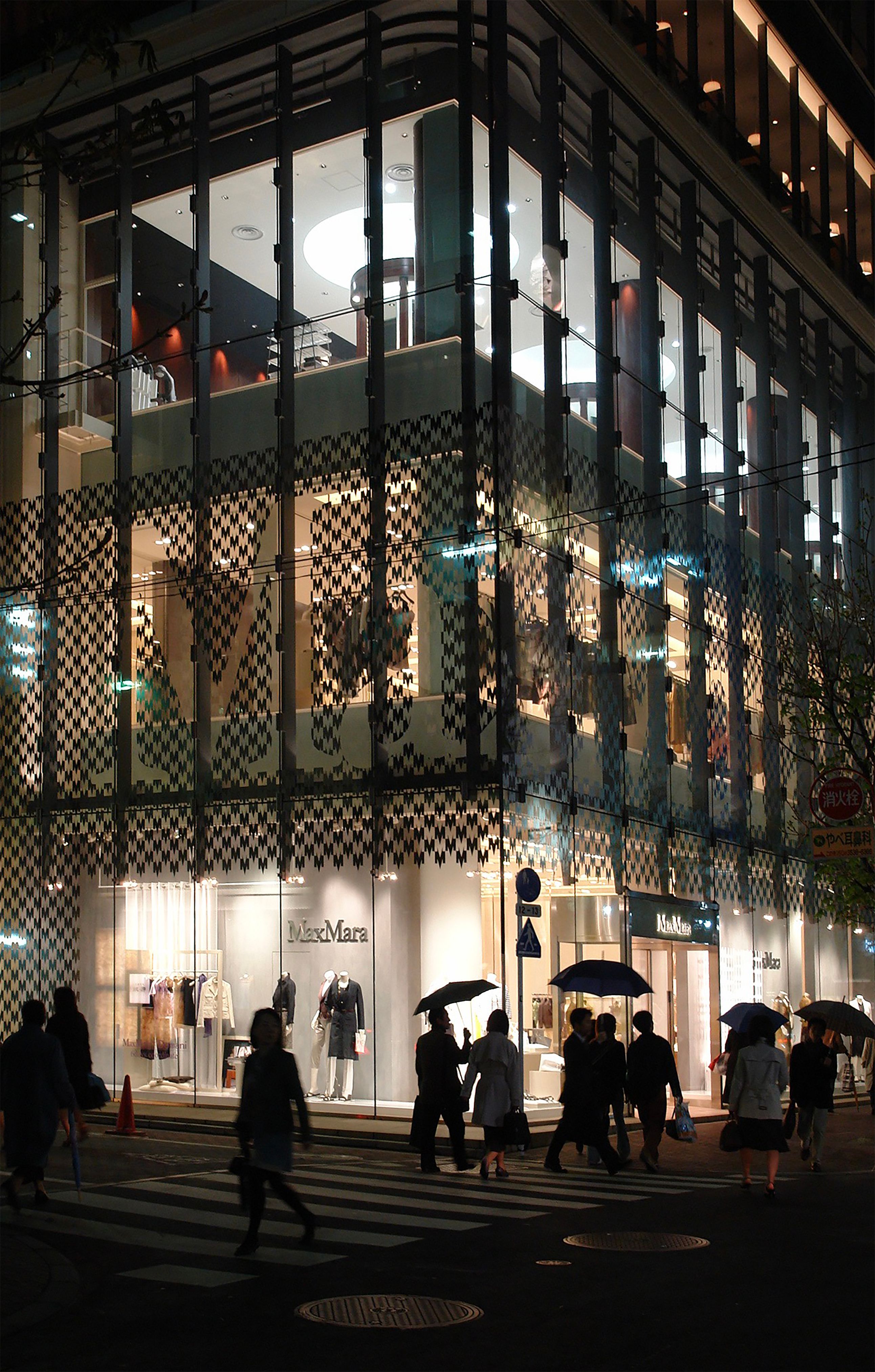 A bustling evening scene at a stylish boutique in Tokyo's Ginza, showcasing vibrant urban life.