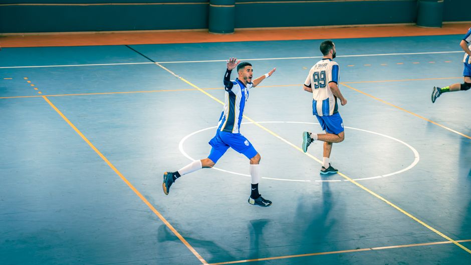 Action-packed indoor futsal game with players in motion on the court.
