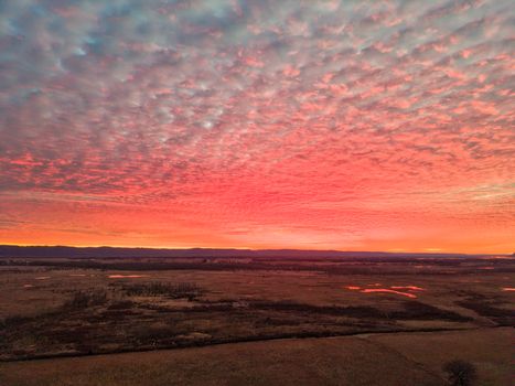 Aerial view of a vibrant sunset over the vast fields of Kellogg, Minnesota, USA.