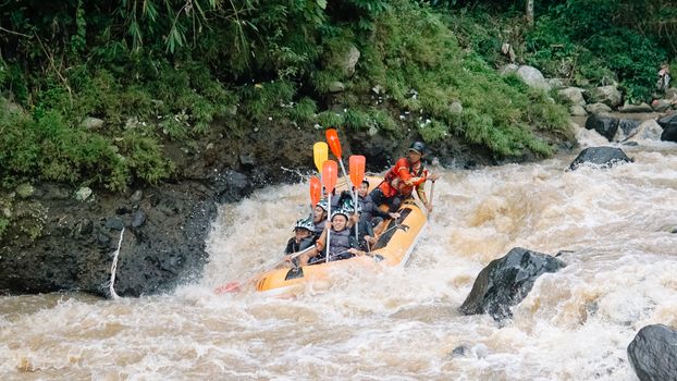 A group enjoying a thrilling whitewater rafting adventure through rocky rapids.