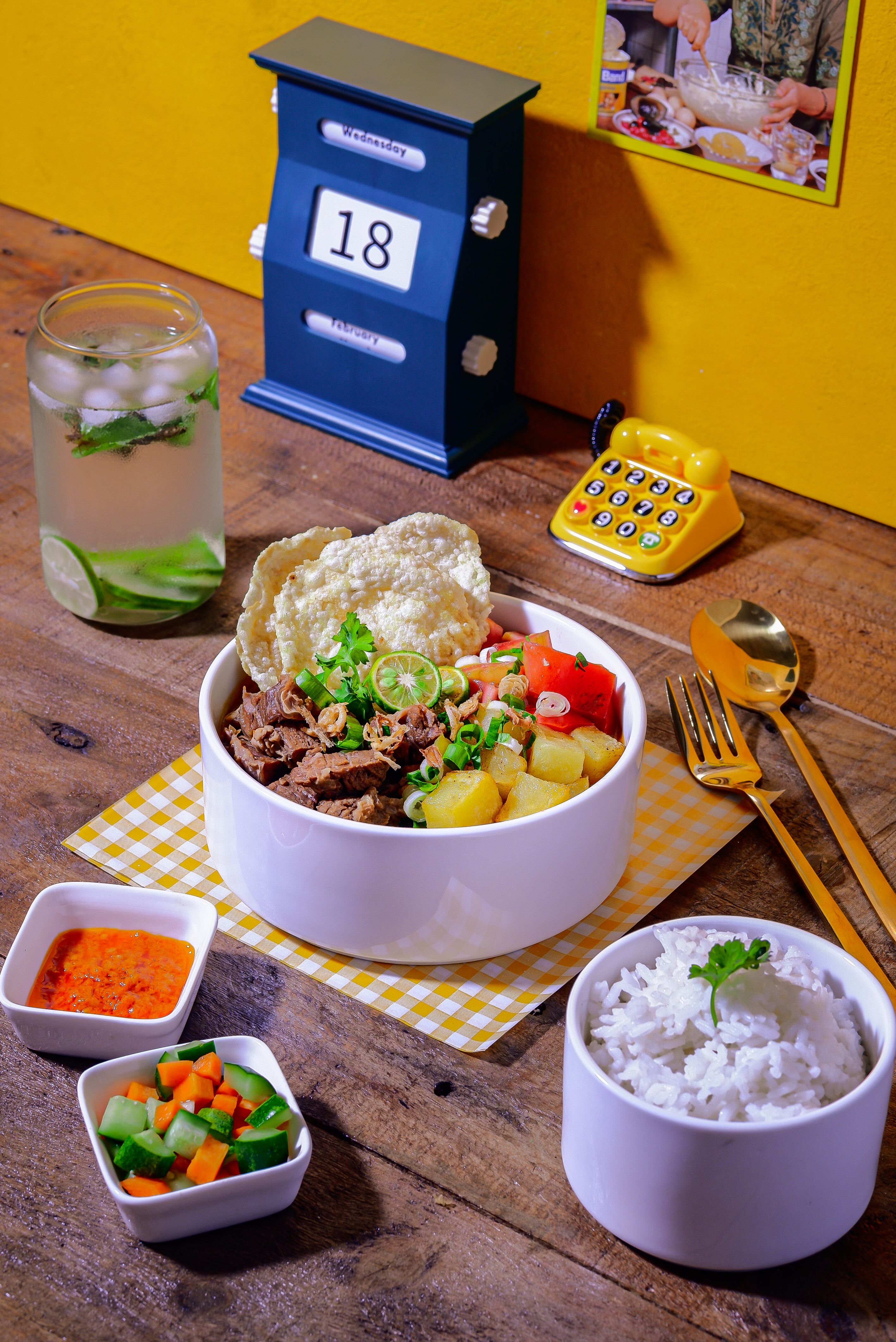 Delicious Asian meal with rice, beef, and vegetables served on a rustic table with refreshing drink.