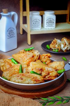 Crispy fried dumplings paired with fresh green chilis, perfect for a spicy appetizer.