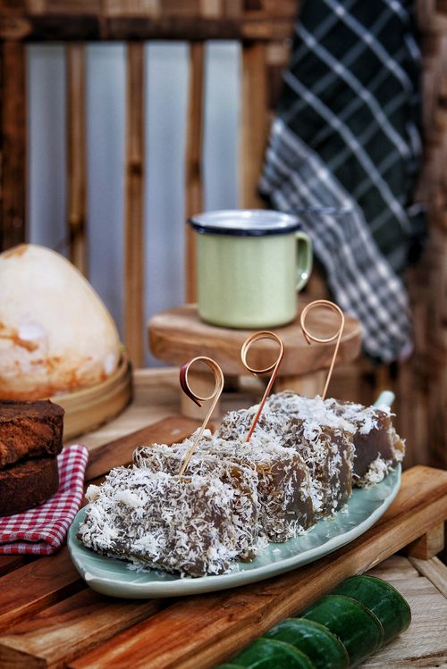 Free A selection of traditional Indonesian desserts with coconut on a rustic wooden table setting. Stock Photo