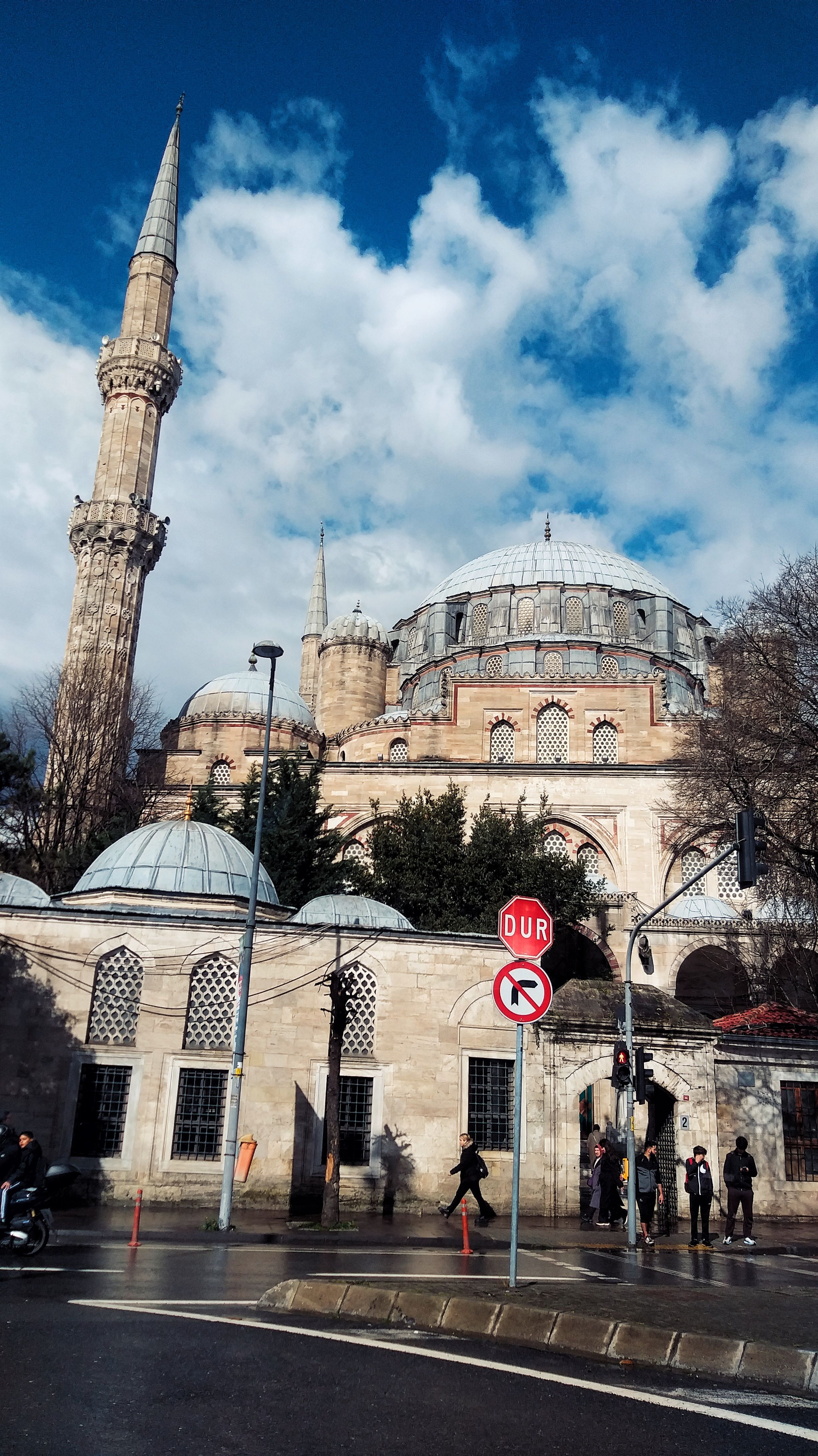 Elegant mosque in Istanbul with a towering minaret and beautiful architecture on a bright day.