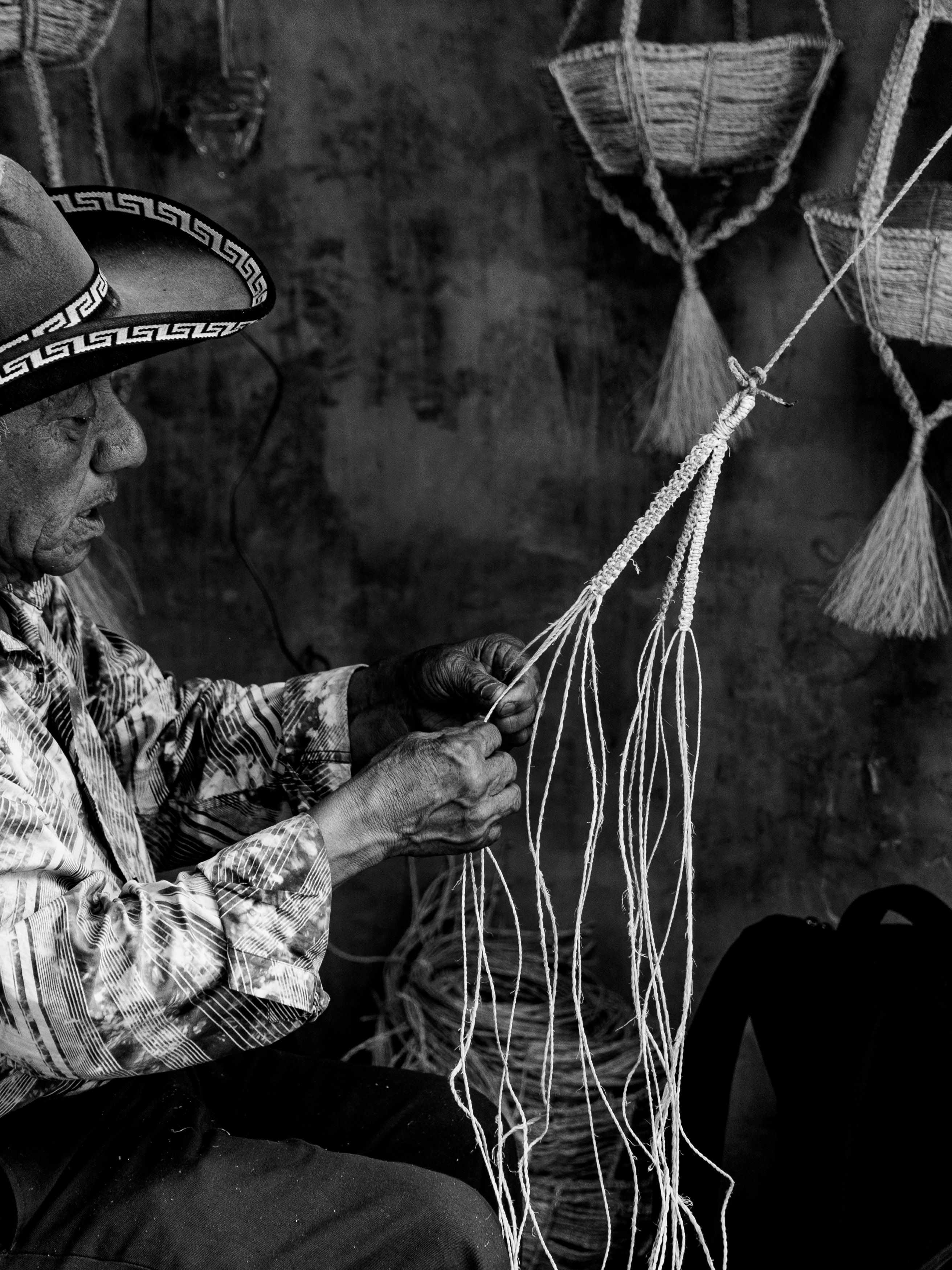 Elderly artisan weaving baskets in Sololá, Guatemala. Captured in black and white for timeless appeal.
