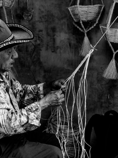 Elderly artisan weaving baskets in Sololá, Guatemala. Captured in black and white for timeless appeal.