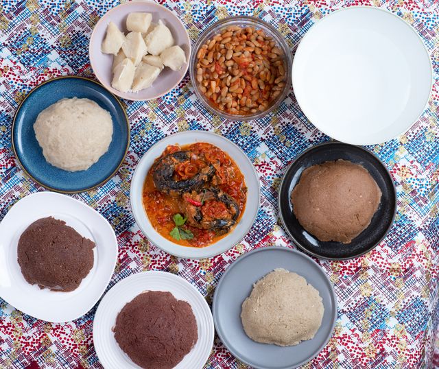A vibrant flat lay of traditional Burundian dishes including ugali, beans, and vegetable sauce.