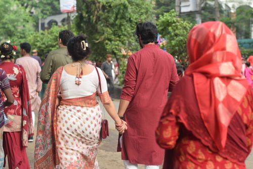Free People dressed in traditional attire walking hand in hand during Pohela Boishakh in Dhaka, Bangladesh. Stock Photo