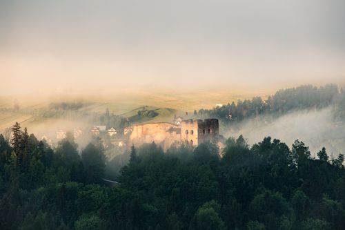 Free A captivating view of ancient ruins amidst misty forests and rolling hills in the Tatra Mountains. Stock Photo