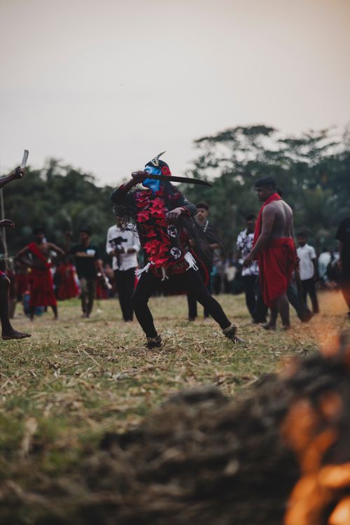 Free A dynamic scene of a traditional cultural dance outdoors with participants in colorful attire. Stock Photo