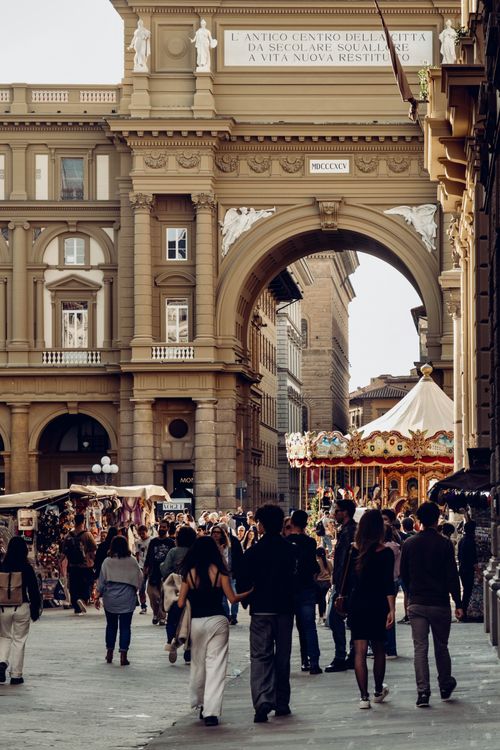 Free People explore Piazza della Repubblica, Florence's historic arch, and vibrant carousel. Stock Photo