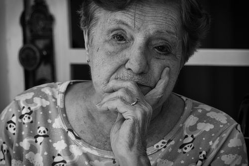 Free Black and white portrait of a senior woman deep in thought, indoors. Stock Photo