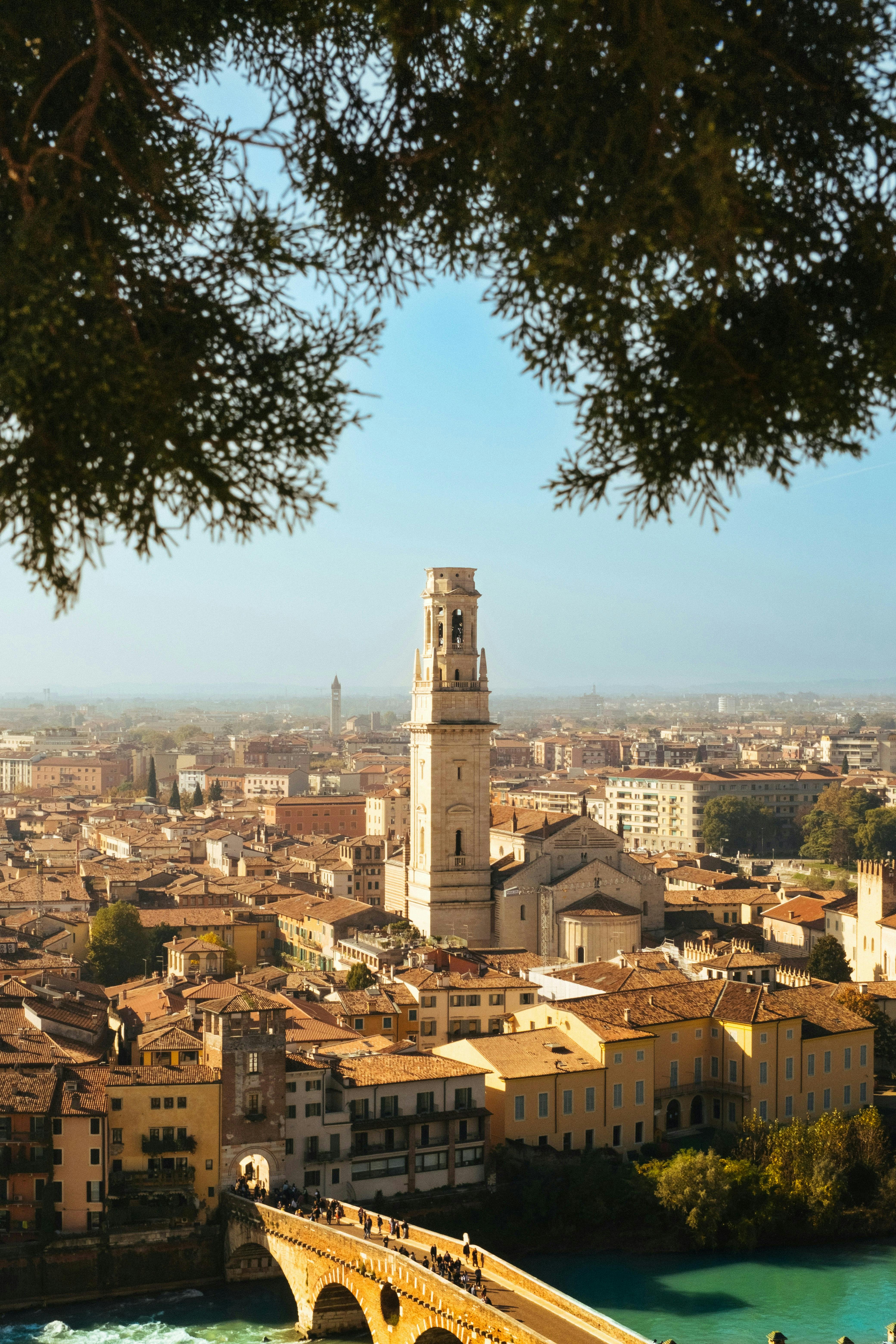 Scenic aerial view of historic Verona, Italy, featuring Ponte Pietra and cityscape under clear skies.